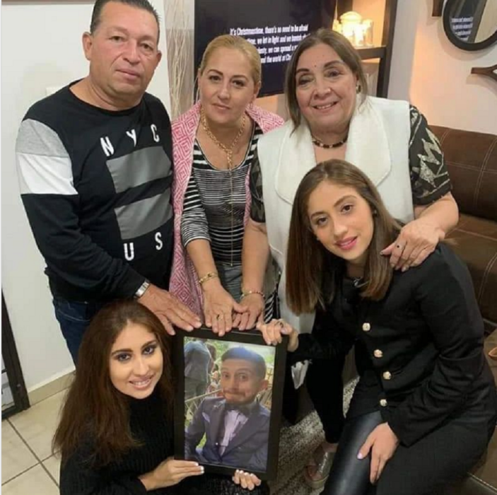 la familia del actor Octavio Ocaña posan en una imagen donde sostienen el cuadro del fallecido actor visten con ropa informal y reflejan tristeza