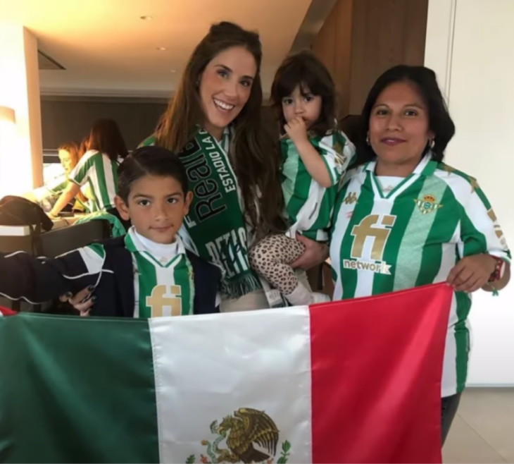 una madre con sus dos hijos y la niñera vestidos con las playeras alusivas a ala Selección Mexicana de futbol están sosteniendo una bandera mexicana