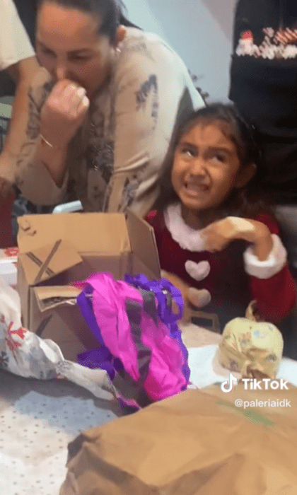 niña llorando al abrir un obsequio que no le gustó está vestida de Santa Claus molesta voltea a ver a quienes se ríen de ella es una captura de pantalla de TikTok