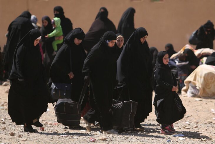 Fotografía de mujeres musulmanes caminando por una calle llena de tierra 