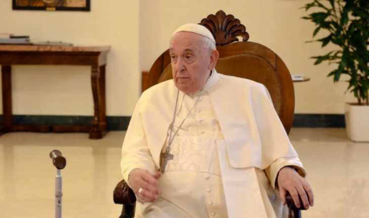 El Papa Francisco sentado en una silla da una entrevista lva vestido completamente de blanco y lleva una cruz colgando de su cuello