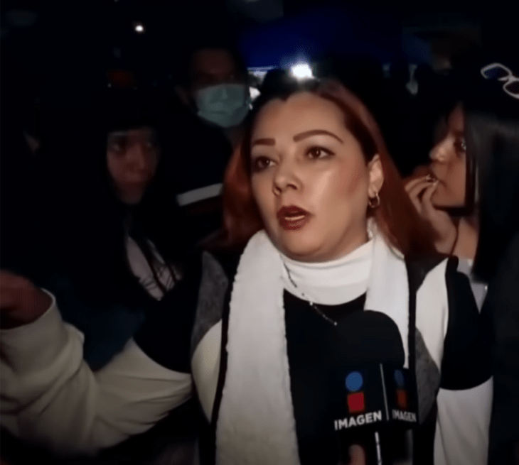 imagen de una señora que es entrevistada por un noticiero a las afueras del estadio Azteca iste ropa invernal y lleva el cabello suelto y maquillaje discreto