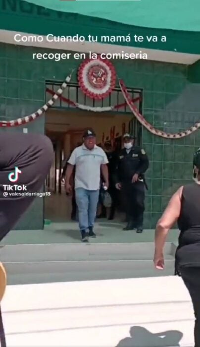 hombre saliendo de una comisaría escoltado por un par de policías en Perú 