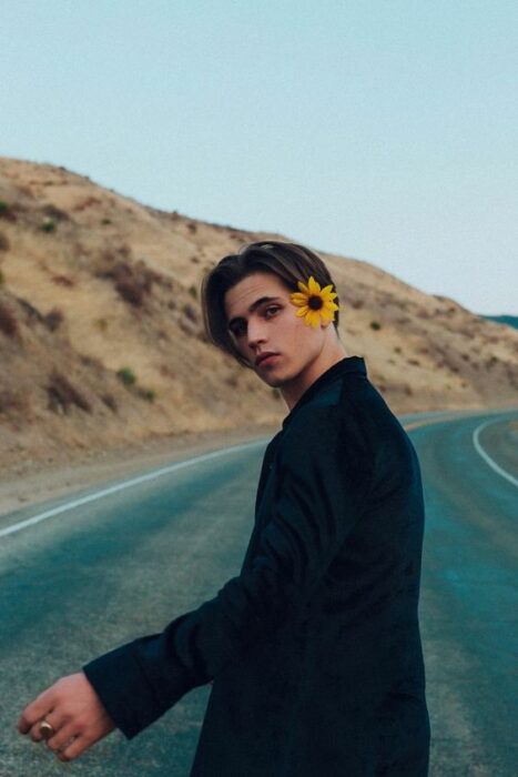 Tanner Buchanan posando en carretera con flor en la cabeza