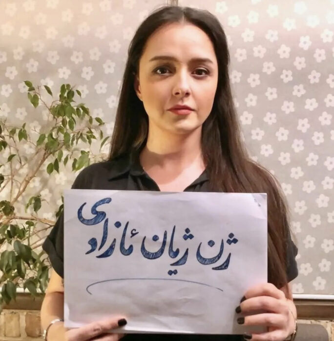 fotografía de la actriz iraní Taraneh Alidoosti con un cartel en la mano y sin velo islámico