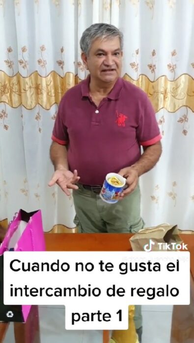 captura de pantalla que muestra a un hombre recibiendo una taza de chocolates en un intercambio de regalos