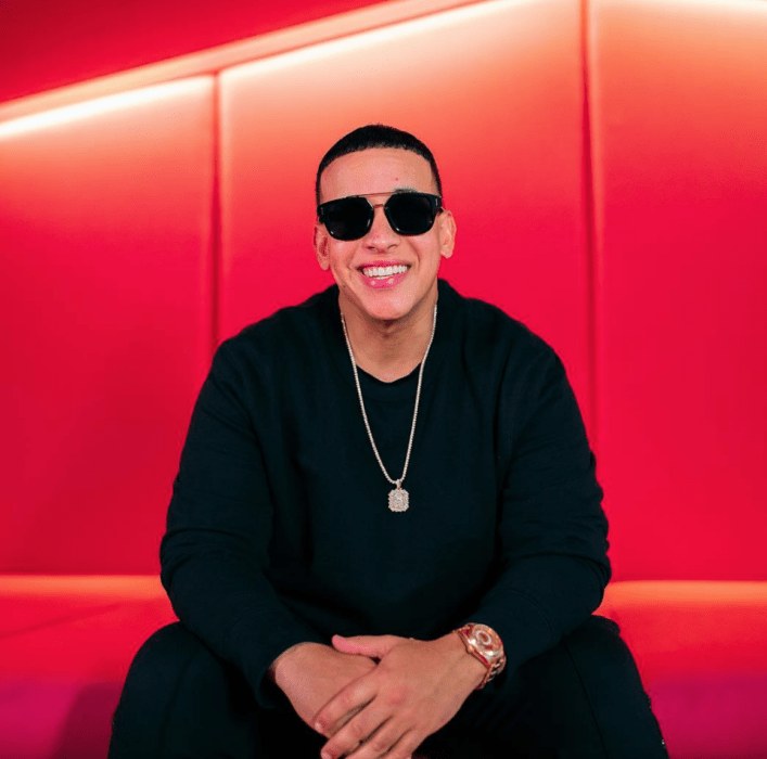 Daddy Yankee sentado fondo rojo