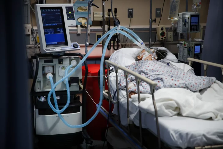Paciente conectada a un respirador artificial en una cama de hospital 