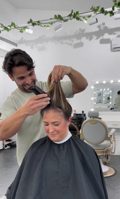 Estilista cortando el cabello a Emily mujer con cáncer