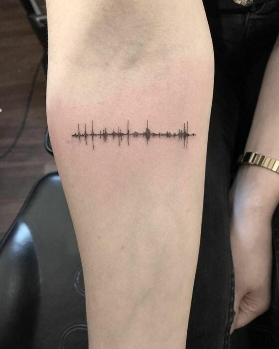 Brazo con tatuaje de nota de voz