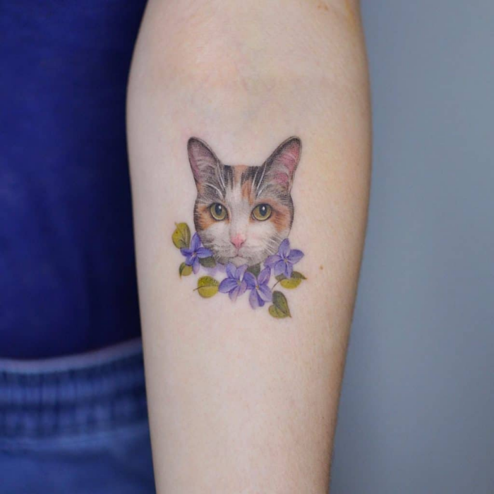 Brazo con tatuaje de gato realista