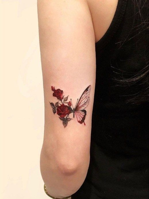 Brazo con tatuaje de mariposa y flores
