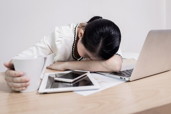 Mujer dormida fatigada sobre el área de trabajo