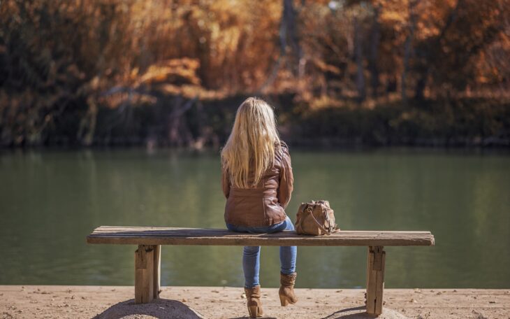 Woman from behind sitting on a bench