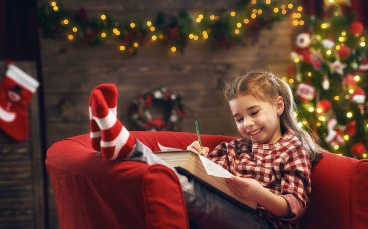 Niña escribiendo carta a Santa Claus navidad