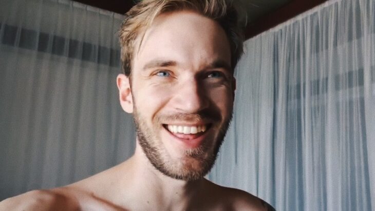 Felix Kjellberg posa para la cámara en una habitación con cortinas blancas lleva el torso desnudo