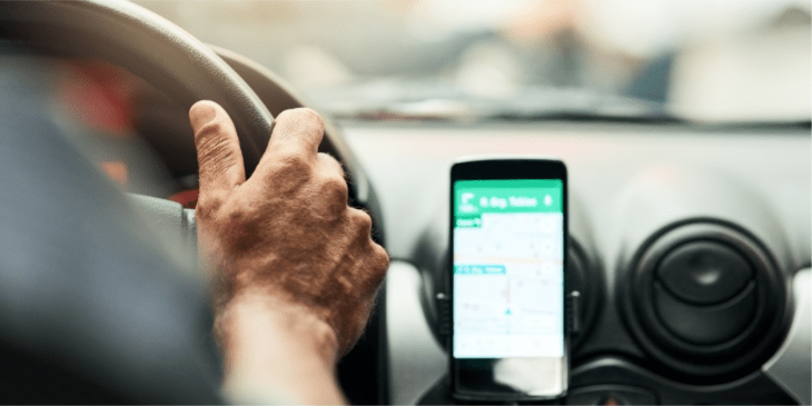 Conductor de uber y celular en tablero