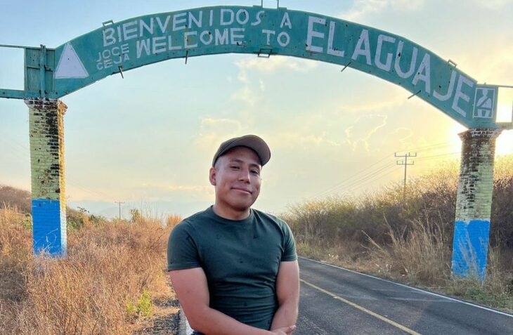 Hombre parado en la carretera en letrero