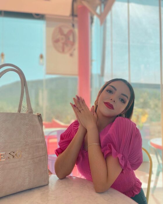 Mujer sentada con blusa rosa