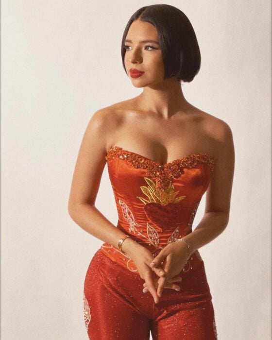 Ángela Aguilar con vestuario rojo de pie
