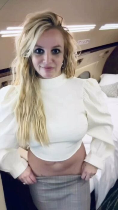 Britney Spears con blusa blanca y falda de cuadros gris 