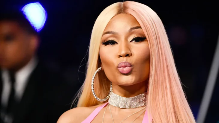 Nicki Minaj posing for the camera with bi-color hair blows a kiss with her lips