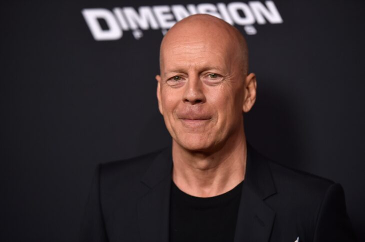 el actor Bruce Willis en un evento lleva un saco negro y playera negra se le ve algo incómodo