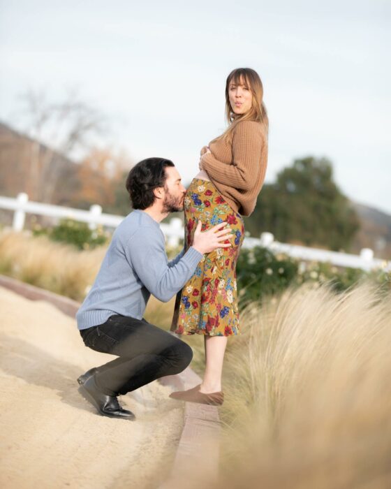 Fotografía que muestra a Tom Pelphrey dándole un beso en la barriga a Kaley Cuoco