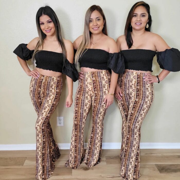 Fotografía de tres chicas posando con el mismo atuendo de pantalón animal print de tigre a juego con un crop top en color negro 