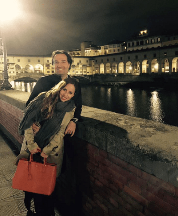 una pareja a la orilla de un lago en la noche están sonriendo