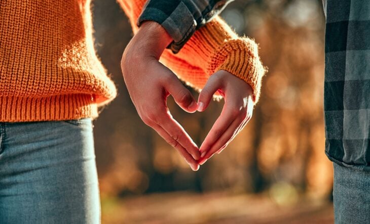 imagen de dos personas formando un corazón con sus manos 