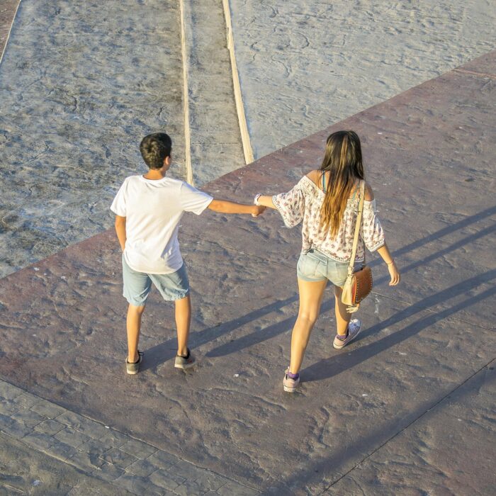 fotografía que muestra a un joven caminando junto a una chica en la calle 