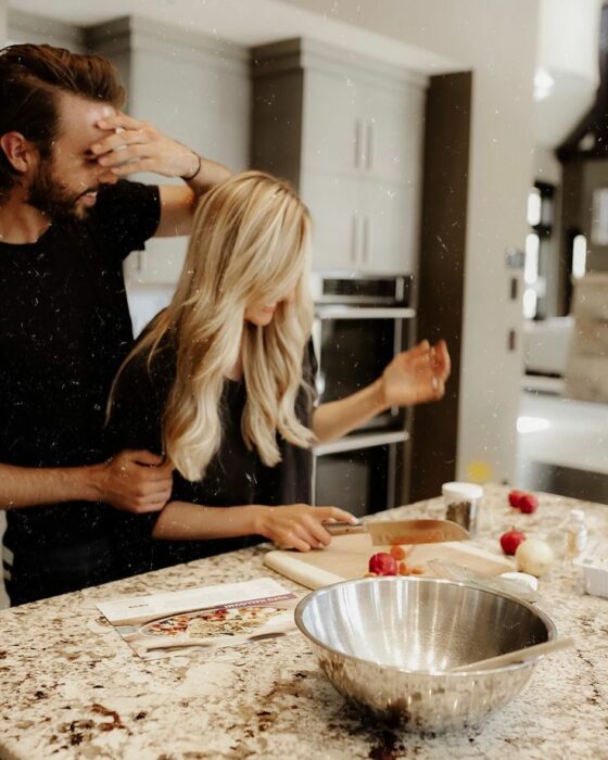 imagen de una pareja cocinando un platillo en la cocina de una casa 