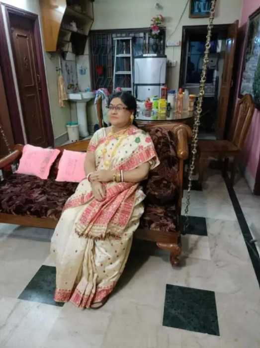 una figura de cera de una mujer de la India está sentada en el sillón de la sala de una casa y lleva la vestimenta típica de la región 