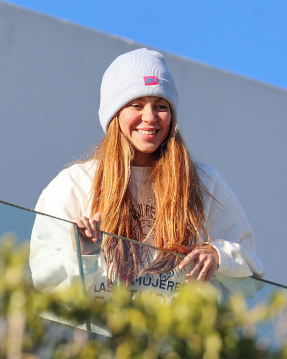 fotografía de Shakira asomada sobre el balcón de su casa usando sudadera y un gorro en la cabeza