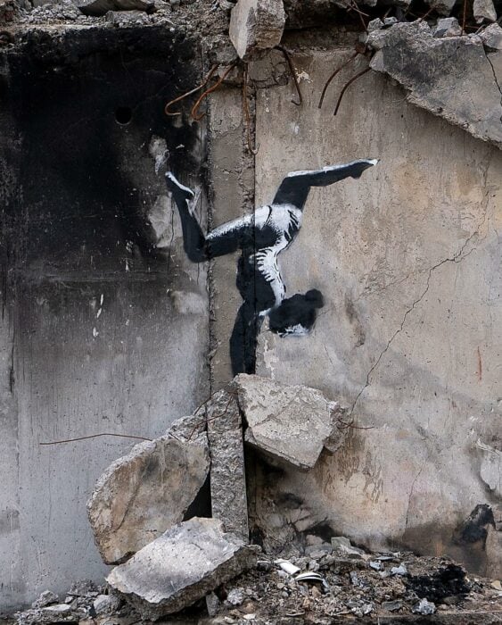 imagen de un grafiti en un edificio de Ucrania que muestra a una niña haciendo gimnasia sobre una piedra 
