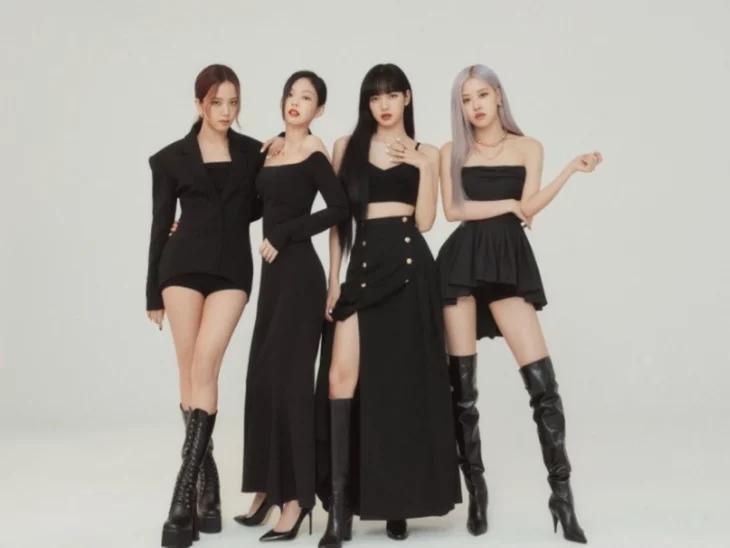 the KPOP BLACKPINK quartet are all dressed in black and posing on a wall with a light background their makeup is marked 