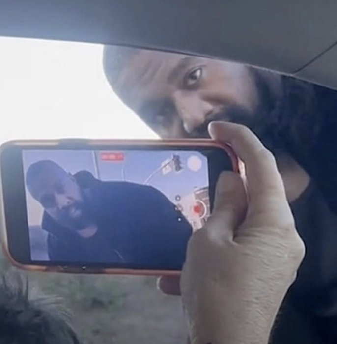 mano de una mujer grabando en su celular al rapero estadounidense Kanye West 