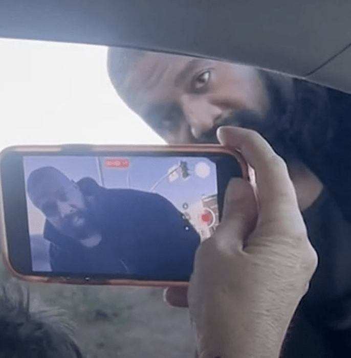 hand of a woman recording American rapper Kanye West on her cell phone 