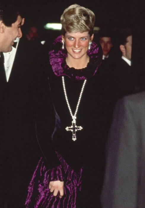 Fotografía de la Princesa Diana de Gales en 1987 usando un vestido color negro a juego con la cruz de attallah 