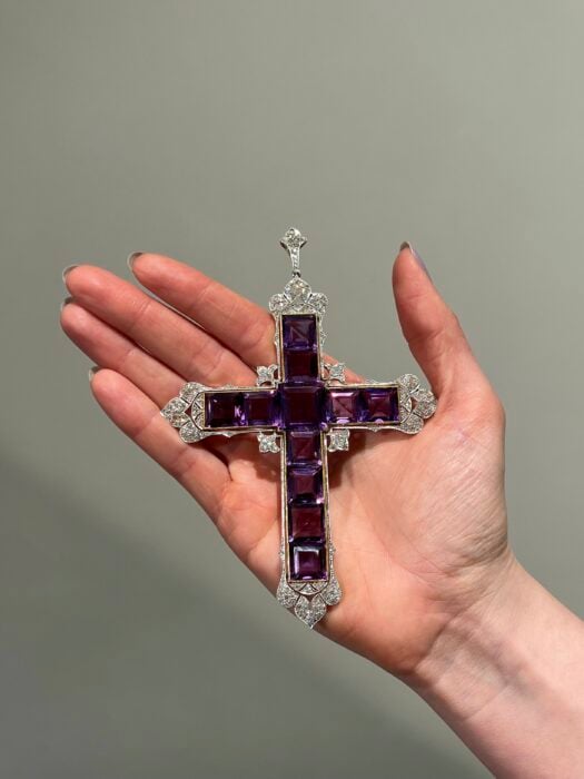 imagen de una mano sosteniendo la famosa cruz de Attallah joya icónica usada por Lady Di 