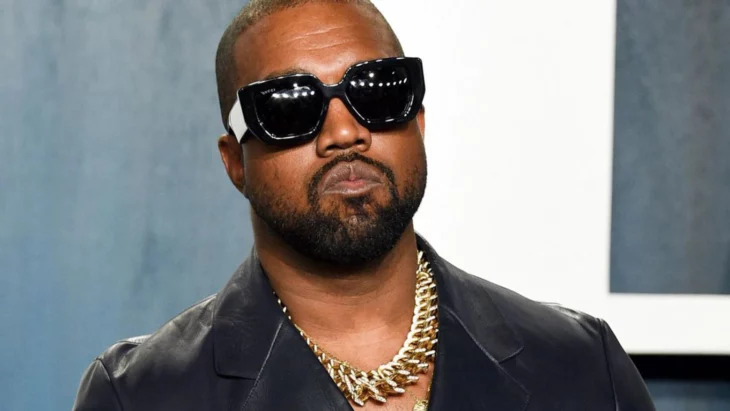 Kayne West posando con lentes oscuros y cadenas de oro en el cuello