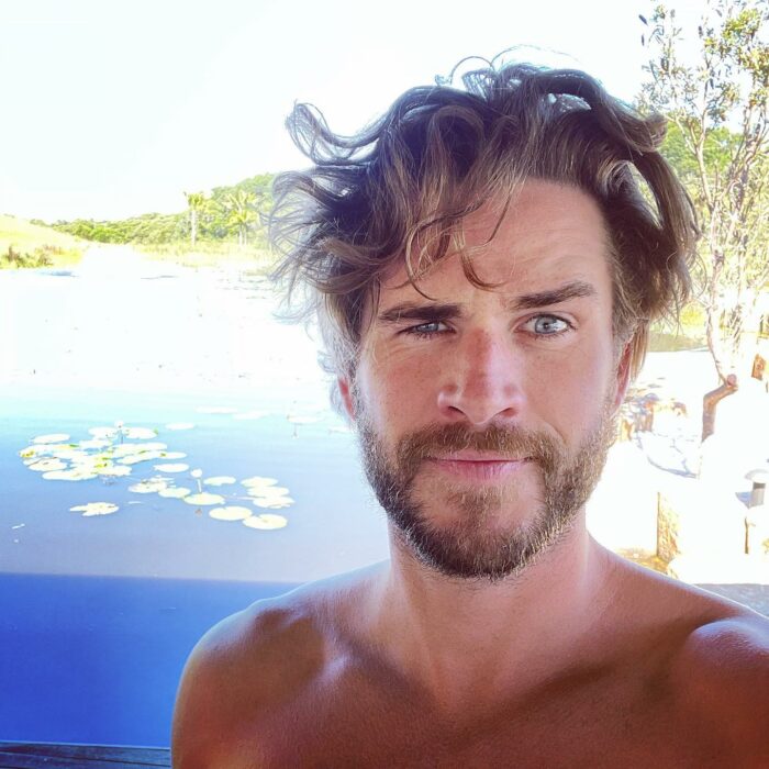 Liam Hemsworth despeinado y guiñando un ojo 