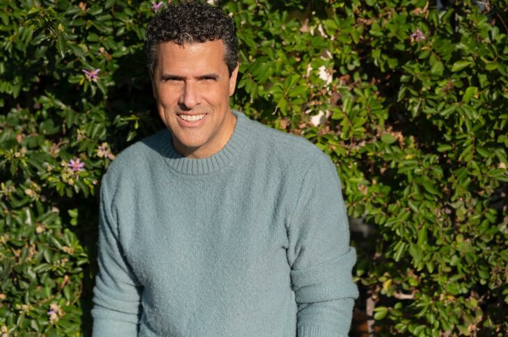 Photograph of the television host Marco Antonio Regil posing on a bush 