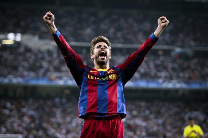 Gerard Piqué celebrando con los brazos en alto en un estadio de futbol