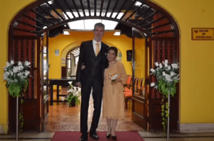 una pareja de novios maduros saliendo de su boda