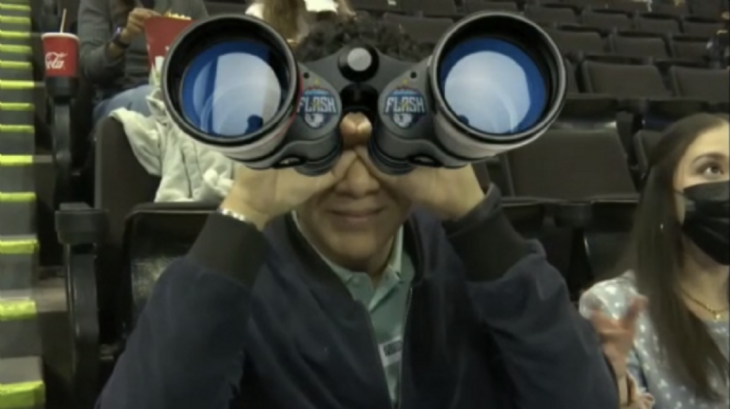 un joven sostiene unos binoculares gigantes falsos