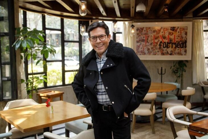 photograph of television host Juan José Origel posing in what appears to be a cafeteria 