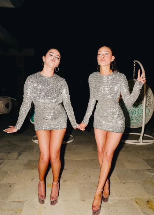 Selena Gomez y Nicola Peltz en una playa mexicana reciebiendo el año nuevo con outfits idénticos de Valentino vestidos gris plateado de lentejuelas con plataformas transparentes de la misma marca