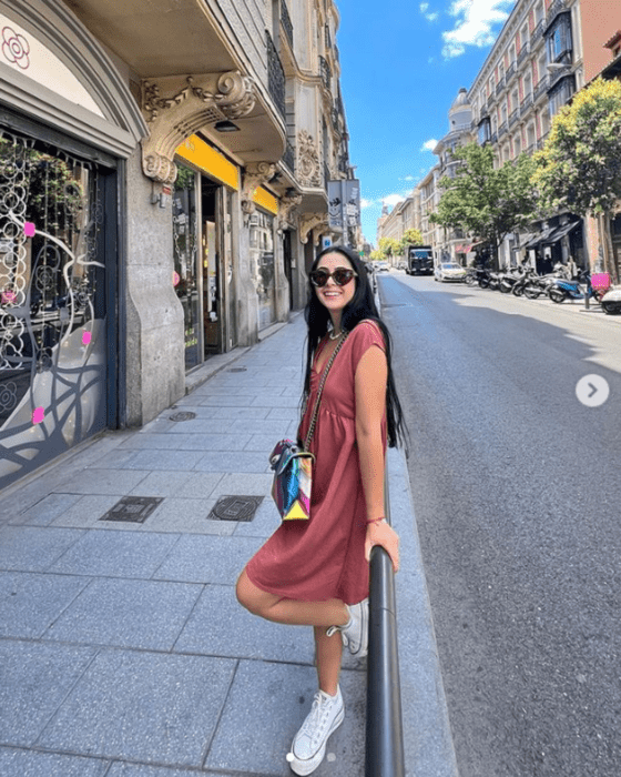 a girl walking through a city in a simple dress